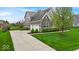 Home with large lawn, and three car garage, enhanced by manicured greenery and brick accents at 1533 Windswept, Brownsburg, IN 46112