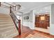 Grand foyer featuring hardwood floors, staircase with iron railings, and a view into the office at 1533 Windswept, Brownsburg, IN 46112