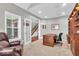 Well-lit home office featuring a comfortable chair and custom shelving at 1533 Windswept, Brownsburg, IN 46112