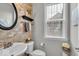 Stylish powder room features travertine backsplash, vanity and neutral accents at 1533 Windswept, Brownsburg, IN 46112