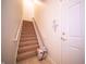 Bright stairway with carpeted steps, accessible chairlift, and a secure white door at 1575 Sierra Springs, Carmel, IN 46280