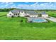 Lush backyard with large home, in-ground pool, covered outdoor kitchen, and well-manicured lawn at 1581 S 825 E, Zionsville, IN 46077