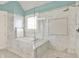 Marble bathroom featuring glass-enclosed shower and jetted tub under window with shutter blinds at 1581 S 825 E, Zionsville, IN 46077