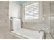 Modern bathroom with a large soaking tub, marble tile, and natural light from the window at 1581 S 825 E, Zionsville, IN 46077