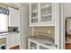 Stylish built-in bar area featuring glass cabinets, marble countertops, and glassware display at 1581 S 825 E, Zionsville, IN 46077