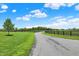Long, private driveway leading to the property, bordered by lush green pastures and black fencing at 1581 S 825 E, Zionsville, IN 46077
