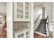 Elegant entryway with a built-in glass cabinet and view of the staircase and hardwood flooring at 1581 S 825 E, Zionsville, IN 46077