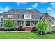 Charming stone home with a covered porch, manicured landscaping, and a gray roof at 1581 S 825 E, Zionsville, IN 46077