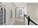 Hallway with neutral carpet, wall art, white trim, and dark staircase banister at 1581 S 825 E, Zionsville, IN 46077