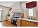 Bright kitchen with custom range hood, stainless steel range and marble countertops at 1581 S 825 E, Zionsville, IN 46077