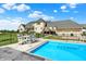 Backyard view featuring a beautiful pool, outdoor dining, lounge chairs, and a stunning home at 1581 S 825 E, Zionsville, IN 46077