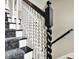 Close-up of staircase with decorative wood spindles and a patterned carpet runner at 1581 S 825 E, Zionsville, IN 46077