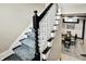 Carpeted staircase with white spindles and black accents leading to a dining area at 1581 S 825 E, Zionsville, IN 46077