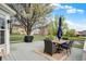 A spacious back deck features a table and chairs, overlooking a picturesque backyard with mature trees and a pond at 15890 Concert Way, Noblesville, IN 46060