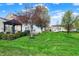 Expansive backyard featuring a lush lawn, patio, deck and mature trees, creating an ideal outdoor space at 15890 Concert Way, Noblesville, IN 46060