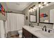 Well-lit bathroom with a double vanity, black hardware, and a shower/tub combo with a curtain at 15890 Concert Way, Noblesville, IN 46060