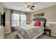 Comfortable bedroom with a queen-size bed, ceiling fan, and large windows providing ample natural light at 15890 Concert Way, Noblesville, IN 46060