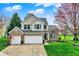 Two-story brick home with three-car garage and a well-manicured lawn at 15890 Concert Way, Noblesville, IN 46060