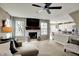 Bright living room with a stone fireplace, mantle mounted television and an open layout to the kitchen at 15890 Concert Way, Noblesville, IN 46060