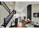 Open-concept living room with hardwood floors, black staircase and decorative lighting at 15890 Concert Way, Noblesville, IN 46060