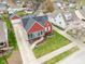 Aerial shot of a red house with sunroom, beautiful landscaping, and a driveway to the garage at 1646 Fisher Ave, Indianapolis, IN 46224