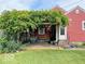 A charming back patio with a vine-covered pergola, seating, and a swing for relaxation at 1646 Fisher Ave, Indianapolis, IN 46224