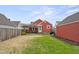 Spacious backyard featuring a patio, storage shed, lush green grass, and privacy fence at 1646 Fisher Ave, Indianapolis, IN 46224