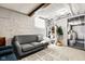 Cozy basement featuring a comfortable gray sofa, exposed beams, and convenient laundry area at 1646 Fisher Ave, Indianapolis, IN 46224