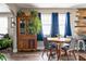 Dining area with wood floors, blue curtains, an antique hutch, and comfortable seating at 1646 Fisher Ave, Indianapolis, IN 46224