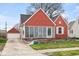 Red home showcasing the exterior with a separate garage and well-maintained lawn and garden at 1646 Fisher Ave, Indianapolis, IN 46224