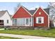 A cozy red home with a unique stone-bordered flower bed adding charm to the front yard at 1646 Fisher Ave, Indianapolis, IN 46224
