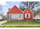 Charming red home with a quaint front yard and a screened-in porch perfect for enjoying the outdoors at 1646 Fisher Ave, Indianapolis, IN 46224