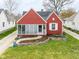 Charming red house with a sunroom, landscaped yard, and a welcoming walkway at 1646 Fisher Ave, Indianapolis, IN 46224