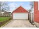 Red garage with a white garage door and concrete driveway, perfect for parking and storage at 1646 Fisher Ave, Indianapolis, IN 46224