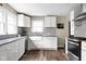 Modern kitchen featuring white cabinetry, stainless appliances, and a mosaic backsplash at 1646 Fisher Ave, Indianapolis, IN 46224