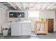 Open concept laundry area with a utility sink, washer, dryer, and shelf at 1646 Fisher Ave, Indianapolis, IN 46224