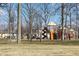 A colorful playground with slides and swings, set among bare trees in a park-like setting at 1646 Fisher Ave, Indianapolis, IN 46224
