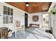 Inviting screened porch featuring vintage decor, a rocking chair, and ample natural light at 1646 Fisher Ave, Indianapolis, IN 46224