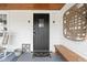 Welcoming front porch with a black door, wooden bench, and charming decorative elements at 1646 Fisher Ave, Indianapolis, IN 46224