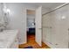 Bright bathroom with marble countertop vanity, glass door shower, and view into bedroom at 1707 Lafayette Ave, Lebanon, IN 46052