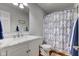 Bathroom with marble vanity, updated fixtures, and blue and white patterned shower curtain at 1707 Lafayette Ave, Lebanon, IN 46052