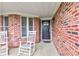 Inviting front door with sidelight windows and porch seating at 1707 Lafayette Ave, Lebanon, IN 46052