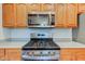 A view of a gas range and Whirlpool microwave with wooden cabinets and light countertops at 1707 Lafayette Ave, Lebanon, IN 46052
