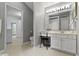 Bright bathroom with vanity, makeup table, white cabinets, and tan tile floors at 17777 Crown Pointe Ct, Noblesville, IN 46062