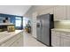 Kitchen with stainless steel refrigerator, white cabinets, and views into the living area with fireplace at 17777 Crown Pointe Ct, Noblesville, IN 46062