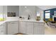 Kitchen area with white cabinetry, sink, dishwasher, and an open view to the dining and living area at 17777 Crown Pointe Ct, Noblesville, IN 46062