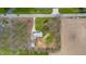 Aerial view of a property with a house and detached garage surrounded by trees and farm land at 1911 N Rangeline Rd, Anderson, IN 46012