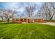 Well-maintained red brick home with a pristine lawn and picturesque landscaping at 1911 N Rangeline Rd, Anderson, IN 46012