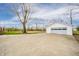 A detached garage with a multi-car door and ample parking space on a concrete driveway at 1911 N Rangeline Rd, Anderson, IN 46012
