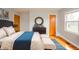 Bright primary bedroom features a plush bed, dark wood dresser, and hardwood floors at 1911 N Rangeline Rd, Anderson, IN 46012